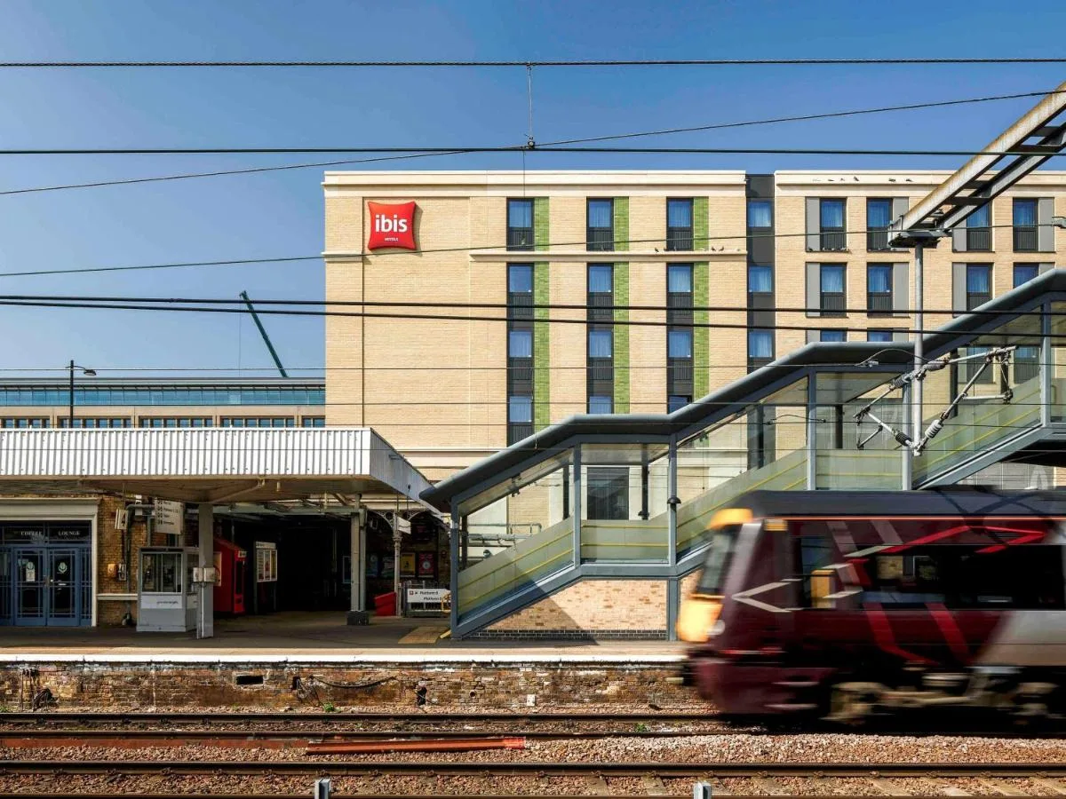 a train on the tracks in front of a building at ibis Cambridge Central Station in Cambridge