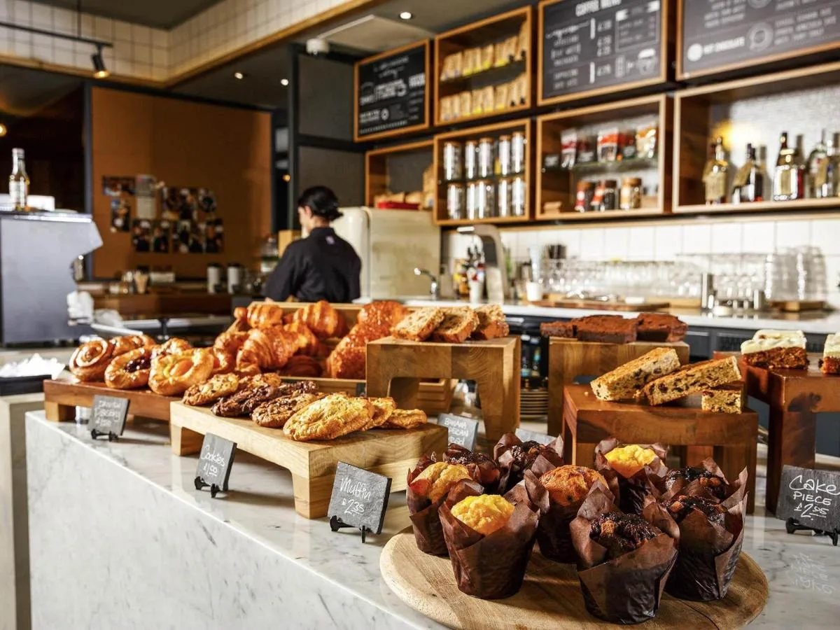 a bakery with many different types of pastries on display at ibis Cambridge Central Station in Cambridge